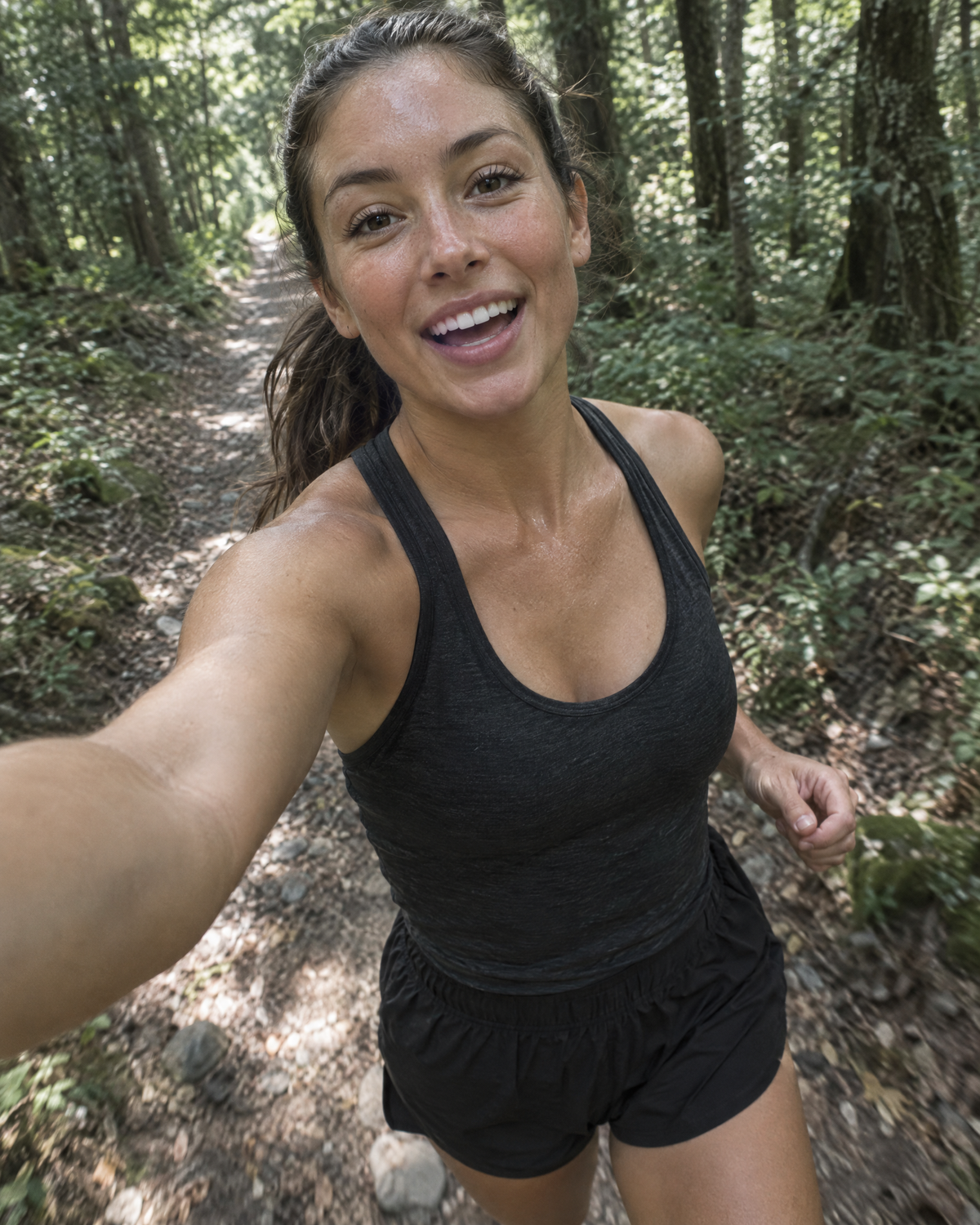 Runner filming herself on a forest trail